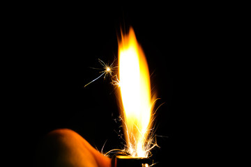 Naklejka premium Close up of lighter fire with sparks explosion on black background