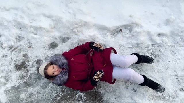 Risk of accidents in winter - A woman slipping on a snow slippery road during freezing cold Russian winter. Close up 4k slow motion video