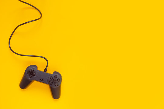 Gamepad connected wire from the game console on yellow background.
