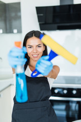 Young pretty woman from a professional cleaning company cleans up at home.