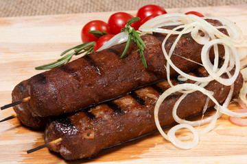 Kebab meat dish on a wooden board..