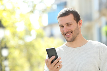 Obraz na płótnie Canvas Happy adult man checking text in a mobile phone