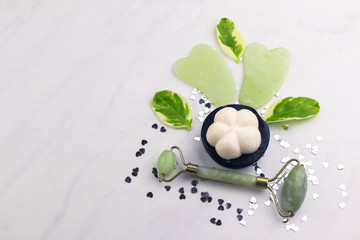 Facial and body stone massage instruments and organic soap  on light background