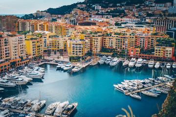Fototapeta na wymiar Monaco Fontvieille cityscape of French Riviera. topview from Monaco Ville, azure water, harbor, luxury apartments, yachts. Port Fontvieille.