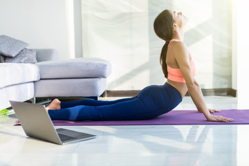 Young pretty woman make yoga exercises at home