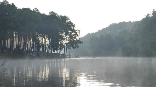 Morning atmosphere Bamboo rafting tourist over the lake Pang Ung Forestry Plantations, Maehongson Province, North of Thailand Asia. Tourist attractions relax with nature. Pan camera Slow Motion