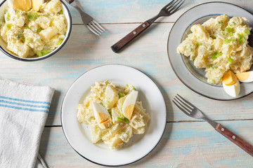Potato salad with egg and mayonnaise on wooden background