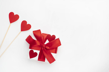 Valentine gift with red ribbon, red hearts made of paper on a white background with copy space for your text