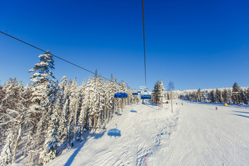 Beautiful vibrant aerial winter mountain view of ski resort, sunny winter day with slope, piste and...