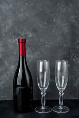 a bottle of red wine and two glasses, stone background for Valentines Day.