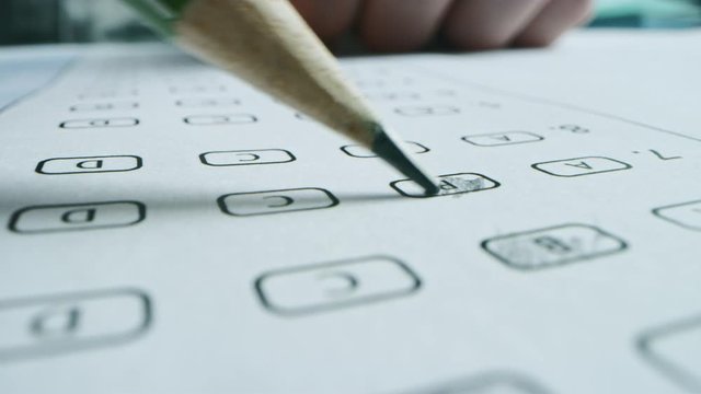 On Exam Test Person Colors Right Answers with a Pencil. Filling up Answer Sheet with Standardized Tests, Marking Correct Answer Bubbles