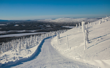 Fototapeta na wymiar Beautiful vibrant aerial winter mountain view of ski resort, sunny winter day with slope, piste and ski lift