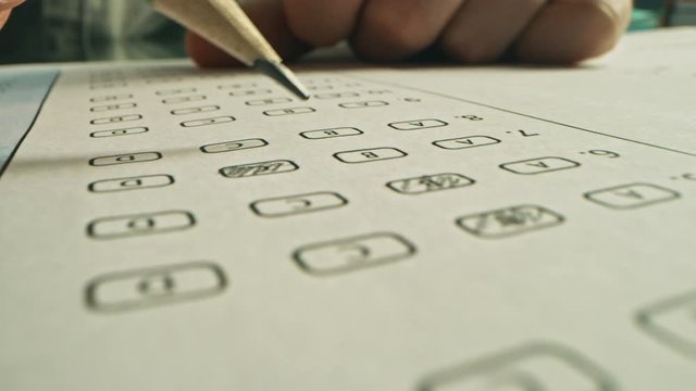 On Exam Test Person Colors Right Answers with a Pencil. Filling up Answer Sheet with Standardized Tests, Marking Correct Answer Bubbles