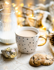 Cozy winter holiday decoration, Christmas lights and coffee cup with decor details, real home