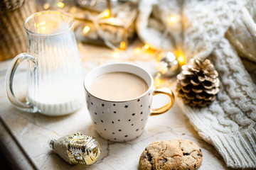 Cozy winter holiday decoration, Christmas lights and coffee cup with decor details, real home