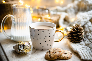 Cozy winter holiday decoration, Christmas lights and coffee cup with decor details, real home