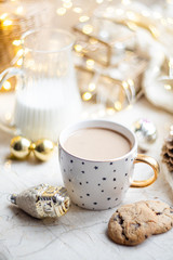 Cozy winter holiday decoration, Christmas lights and coffee cup with decor details, real home