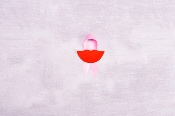 Healthcare and medicine concept - pink breast cancer awareness ribbon with paper gray background,...