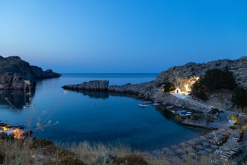 Fototapeta na wymiar Scenic view at Saint Pauls bay in Lindos on Rhodes island, Greece during blue hour in the evening