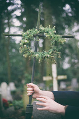 Mężczyzna trzymający krzyż na cmentarzu