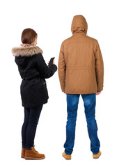 Back view of couple in winter jacket photographed on a mobile phone in winter jacket.