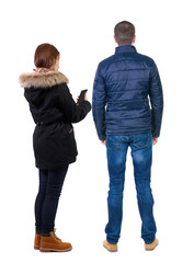 Back view of couple in winter jacket photographed on a mobile phone in winter jacket.