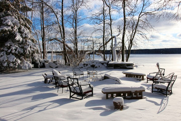 Beautiful Midwest snowy winter nature background. Scenic rural view with covered by fresh snow backyard of the private house with outdoor furniture. Wisconsin countryside, Wausau area.