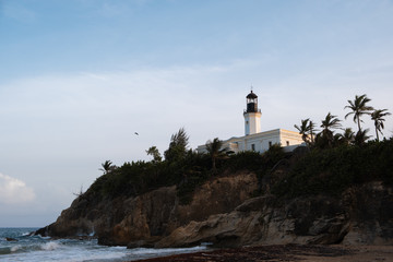 Fototapeta na wymiar lighthouse at sunset by the sea an d a cliff