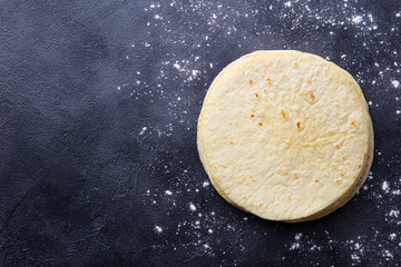 Tortillas, flat breads on dark grey background. Copy space. Top view.
