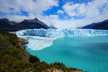 Naklejka premium Perito Moreno glacier with blue skies and ice bridge, looking south