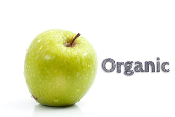 Organic word written on isolated background with fresh green apple