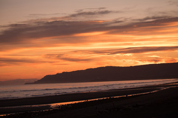 Fototapeta na wymiar Colorful summer sunset over the beach and bluffs – Homer, Alaska