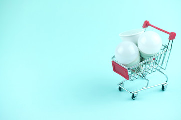 led lamps in a shopping cart near home and money, the concept of energy saving and environmental...