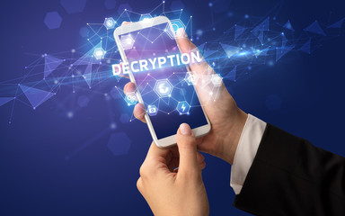 Female hand holding smartphone with DECRYPTION inscription, modern technology concept