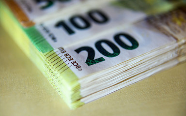 Euro Banknoten liegen gestapelt auf einem Tisch.