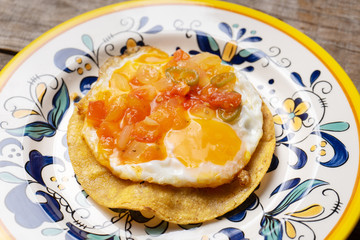 Mexican egg mounted on corn tortilla with sauce also called 