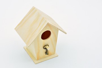 Casita nido de madera con una llave colgada en la entrada