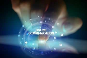 Finger touching tablet with social media icons and ONLINE COMMUNICATION