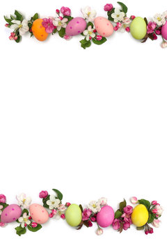 Easter decoration. Easter frame of pink flowers apple tree and colored easter eggs on white background with space for text. Top view, flat lay