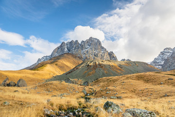 dramatic mountain landscape in Juta trekking area landscape with snowy  mountains in sunny autumn day -  popular trekking  in the Caucasus mountains, Kazbegi region, Georgia.