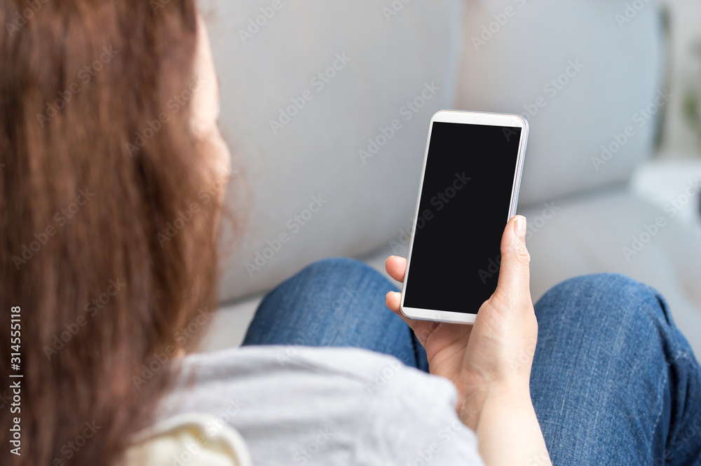 Sticker woman hand using a smart phone with blank screen lying on a couch