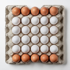 Carton of fresh brown and white eggs on white background