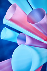 Background from multi-colored plastic cocktail tubes on a dark background