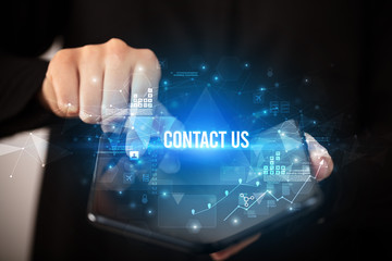 Businessman holding a foldable smartphone with CONTACT US inscription, business concept
