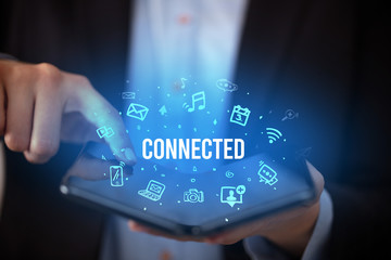 Businessman holding a foldable smartphone with CONNECTED inscription, social media concept
