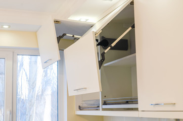 Kitchen wall cabinets with MDF facades and a folding opening mechanism in light beige.