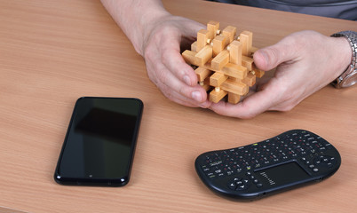 Obraz premium Person chooses a wooden puzzle instead of electronic devices