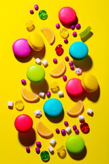 Macaroons dessert and candies on colorful background. Top view.