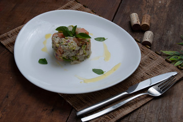 Tartar salmon with herbs on white dish
