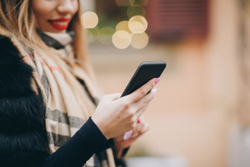 Adult Caucasian Woman is Using Smartphone App Outside near Modern Building. Woman with smartphone...